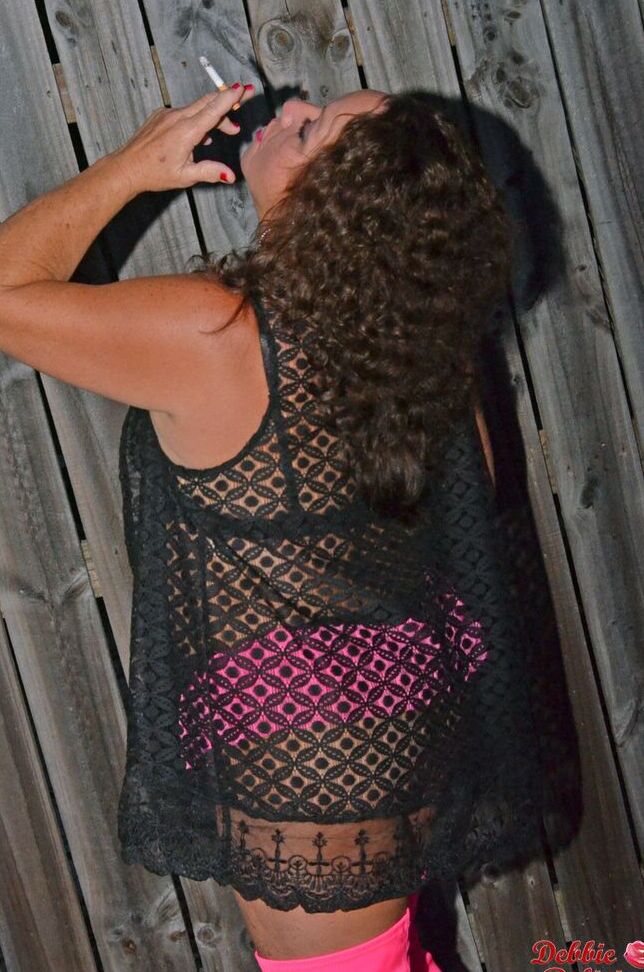 20P Fat amateur Debbie Delicious smokes while exposing her breasts in long boots