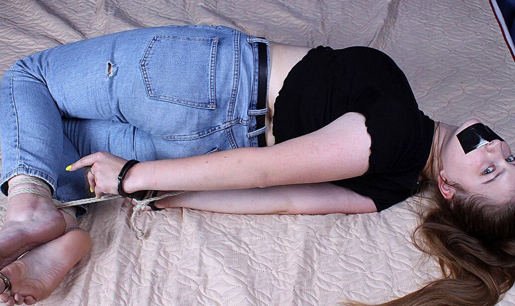 16P 服を着た女の子がベッドに手錠をかけられ拘束されながらダクトテープで沈黙させられる