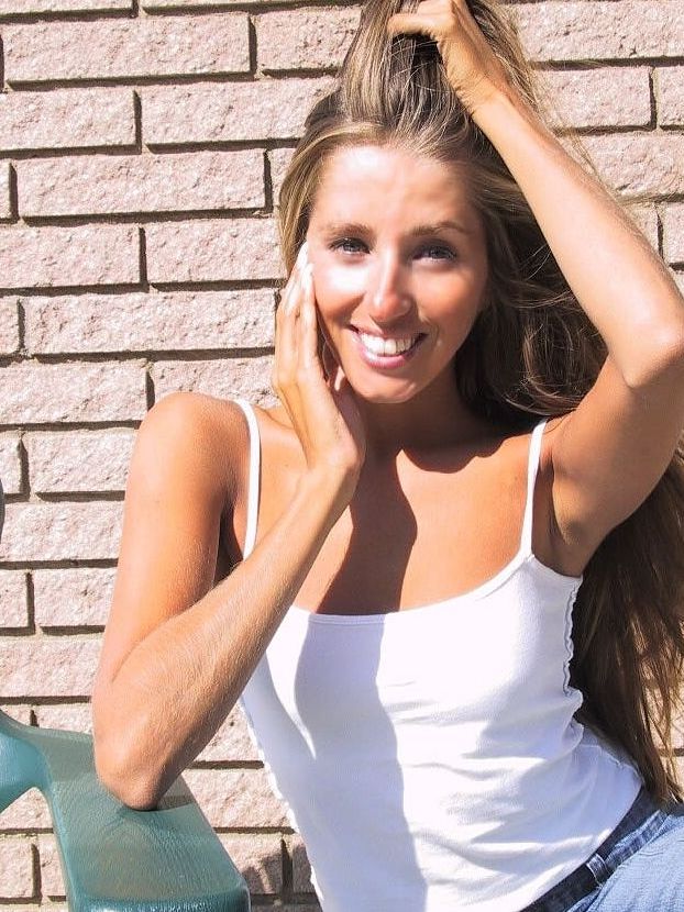 21P La encantadora y sexy Lori Anderson jugando con el pelo largo de su brazo al aire libre
