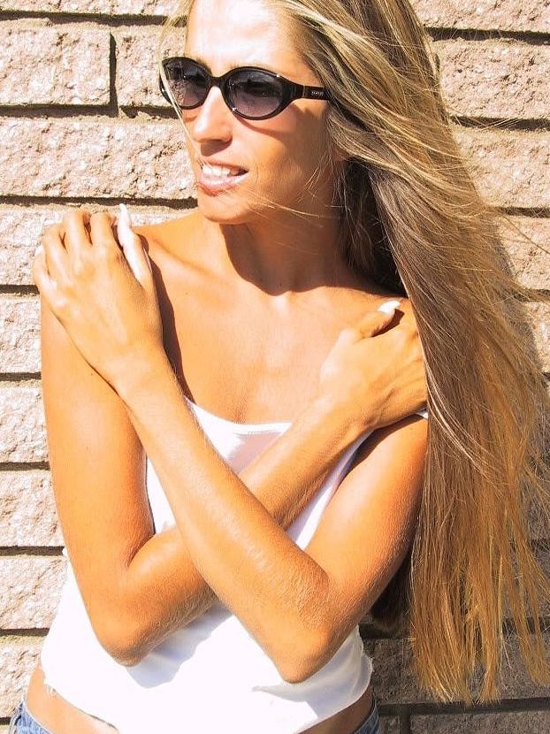 21P La encantadora y sexy Lori Anderson jugando con el pelo largo de su brazo al aire libre