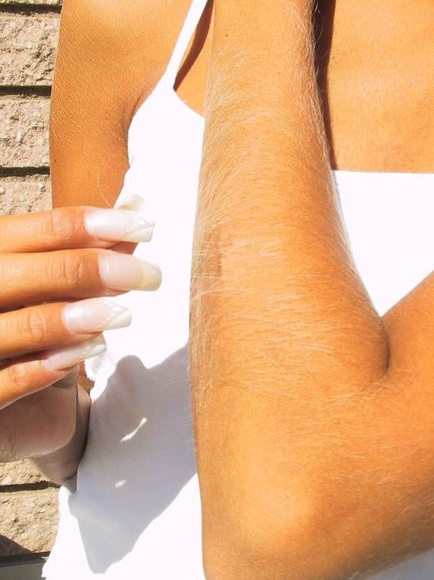 21P La encantadora y sexy Lori Anderson jugando con el pelo largo de su brazo al aire libre