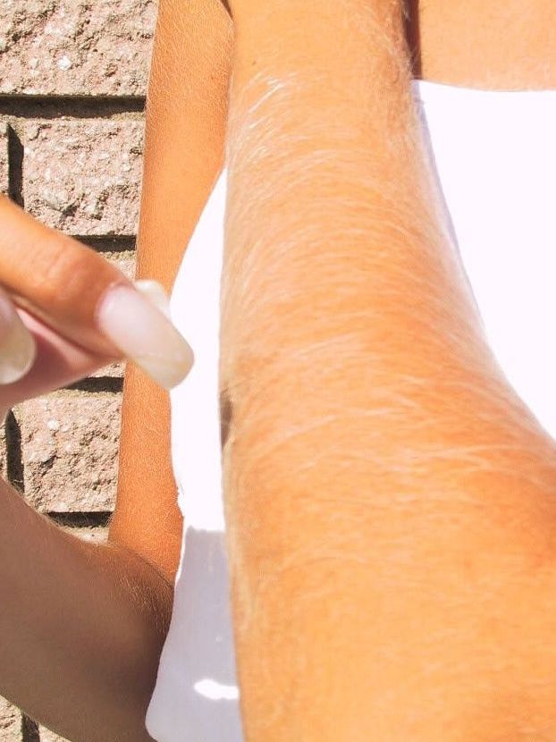 21P La encantadora y sexy Lori Anderson jugando con el pelo largo de su brazo al aire libre