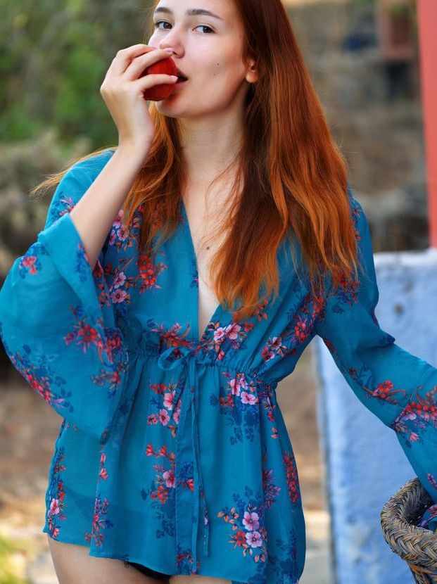 18P Beautiful red haired Janey takes a bite of an apple, divests her clothing and