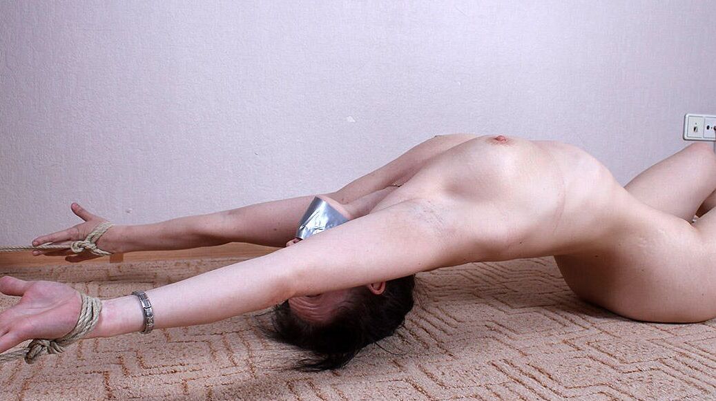 16P Caucasian girl Bianca arches her back while tied to the floor and gagged