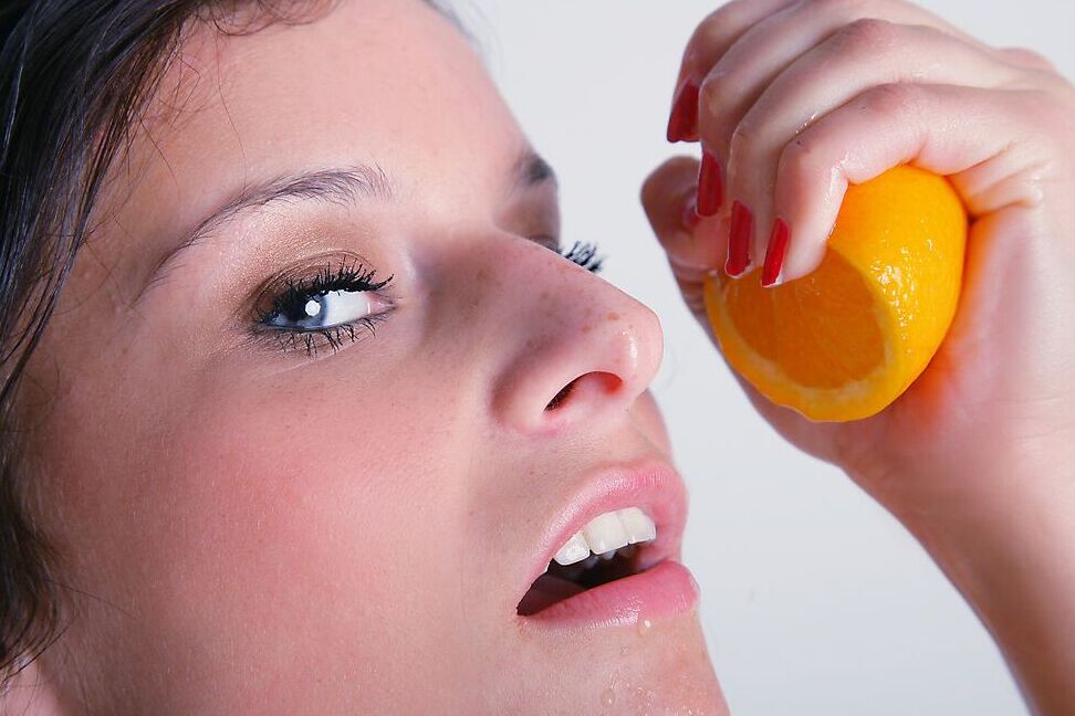 16P Dark haired model removes black legging before squeezing an orange in the nude