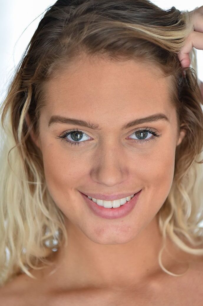 21P Die wunderschöne blonde Athena enthüllt ihre perfekten Melonen und posiert nackt auf einem Stuhl