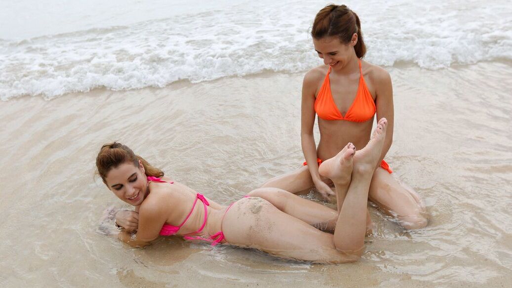 12P Sexy beach bikini twins frolic around at the water's edge in public