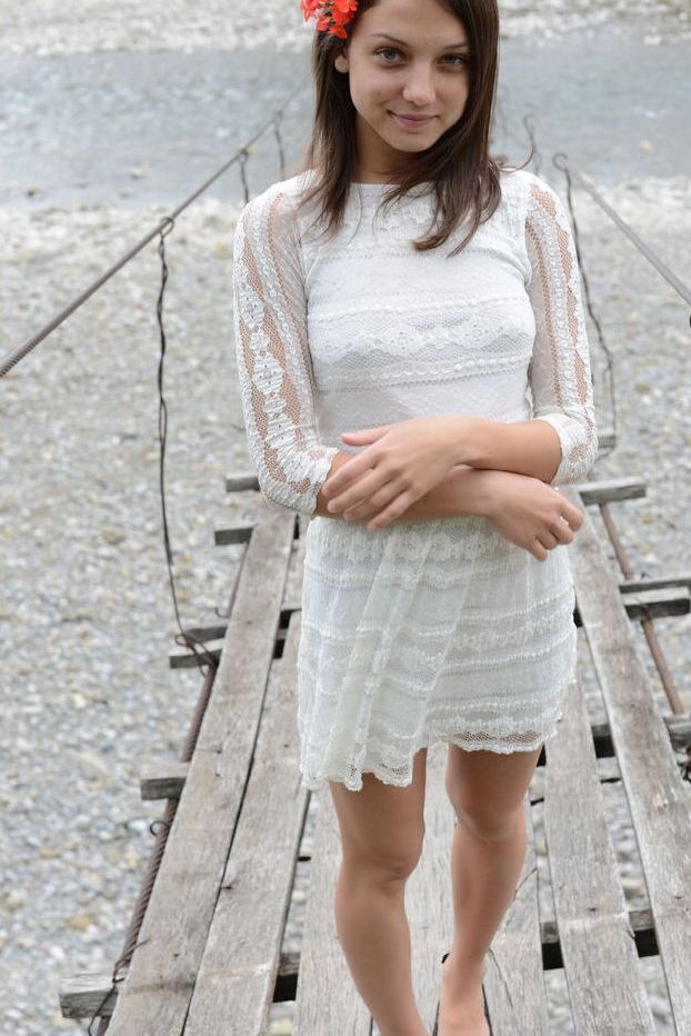 20P Petite adolescente porte une fleur dans les cheveux en posant nue sur un pont suspendu