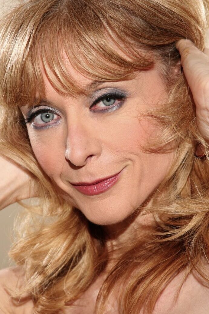 20P A loira glamorosa Nina Hartley faz topless para mostrar seus peitos lindos em meia-calça