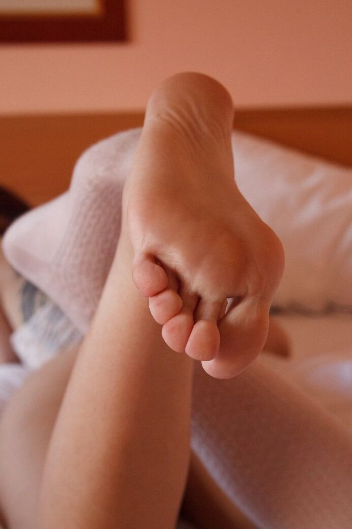 12P A adolescente italiana Jaye Lough flexiona os dedos dos pés descalços após remover a meia do joelho