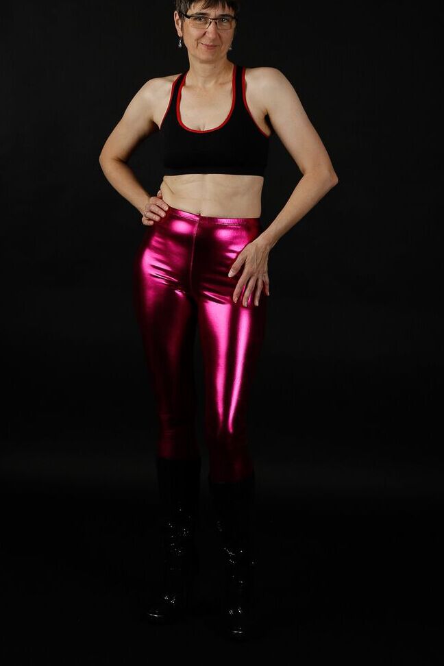 20P Femme mature modèle un soutien-gorge de sport dans un pantalon brillant et des bottes noires