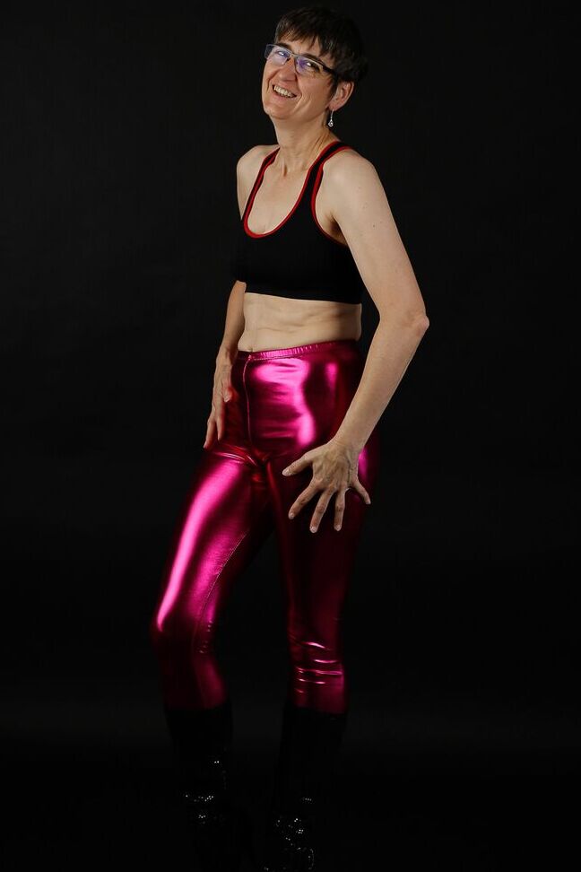 20P Femme mature modèle un soutien-gorge de sport dans un pantalon brillant et des bottes noires