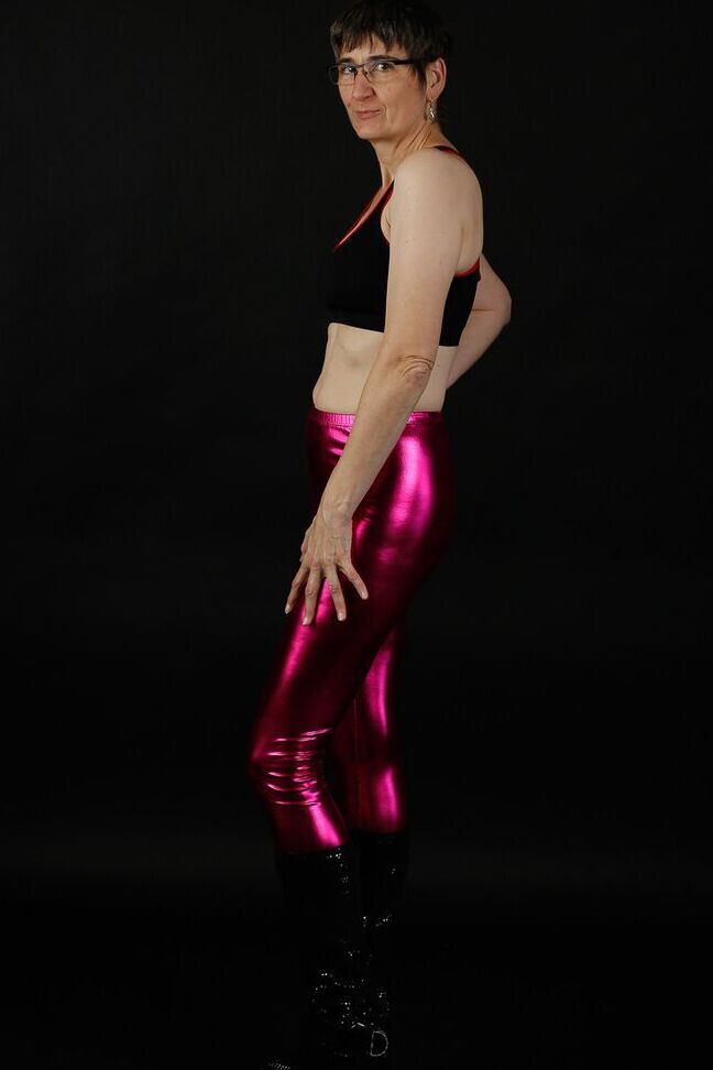 20P Femme mature modèle un soutien-gorge de sport dans un pantalon brillant et des bottes noires