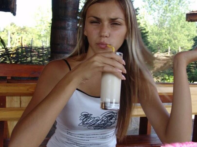 15P Versauter blonder Teenager schlürft einen Milchshake in einem kurzen Jeansrock