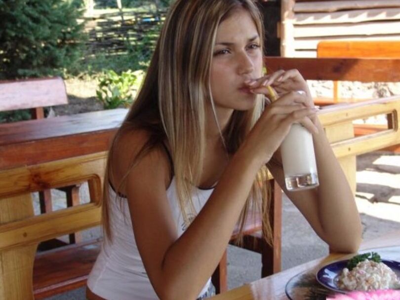 15P Versauter blonder Teenager schlürft einen Milchshake in einem kurzen Jeansrock