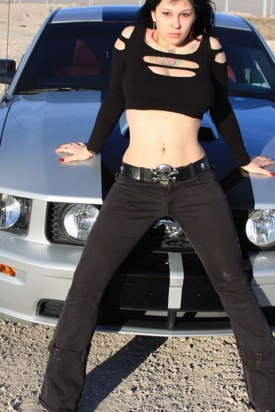 20P A garota sexy Susy Rocks expõe o sutiã sobre o capô de um carro em óculos escuros