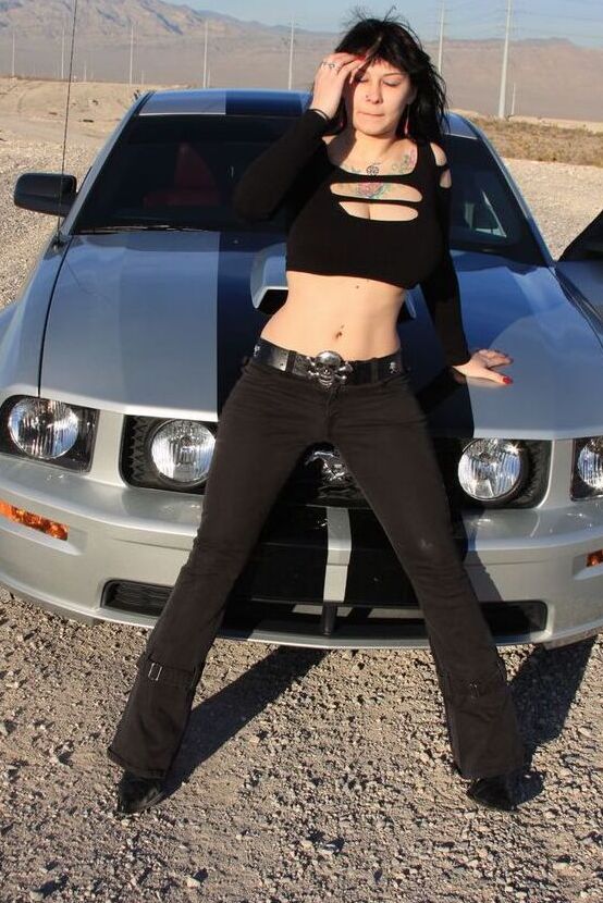 20P A garota sexy Susy Rocks expõe o sutiã sobre o capô de um carro em óculos escuros
