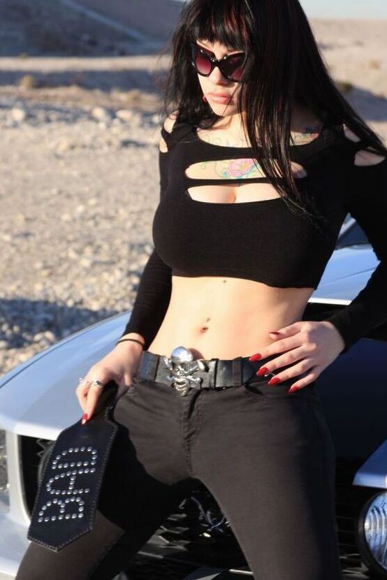 20P A garota sexy Susy Rocks expõe o sutiã sobre o capô de um carro em óculos escuros