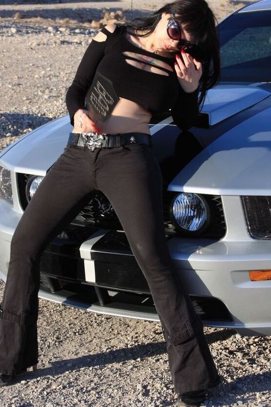 20P A garota sexy Susy Rocks expõe o sutiã sobre o capô de um carro em óculos escuros