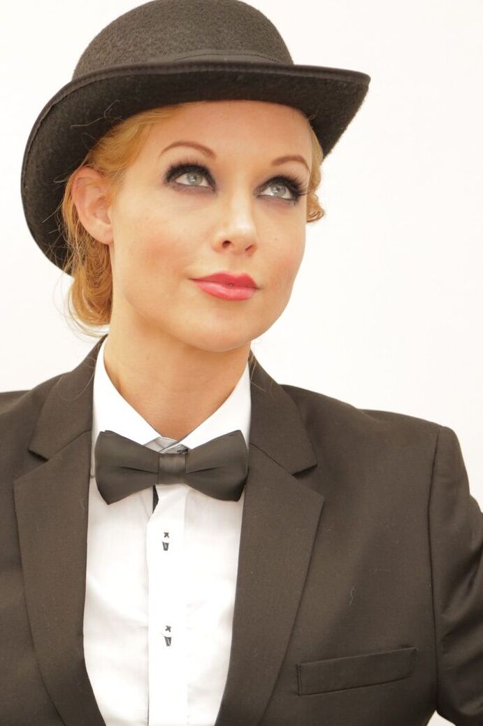 17P La pornostar rubia Kayden Kross posando con traje y sombrero en casa