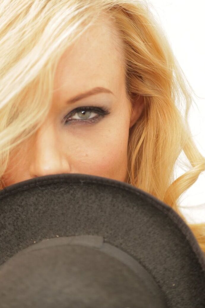 17P La pornostar rubia Kayden Kross posando con traje y sombrero en casa