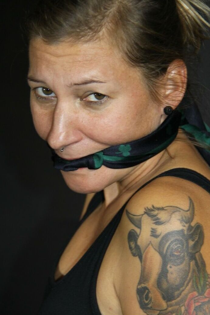 16P A menina tatuada Sandra está amordaçada com as mãos amarradas acima da cabeça
