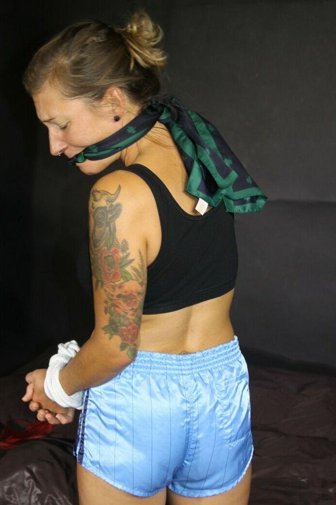 16P A menina tatuada Sandra está amordaçada com as mãos amarradas acima da cabeça