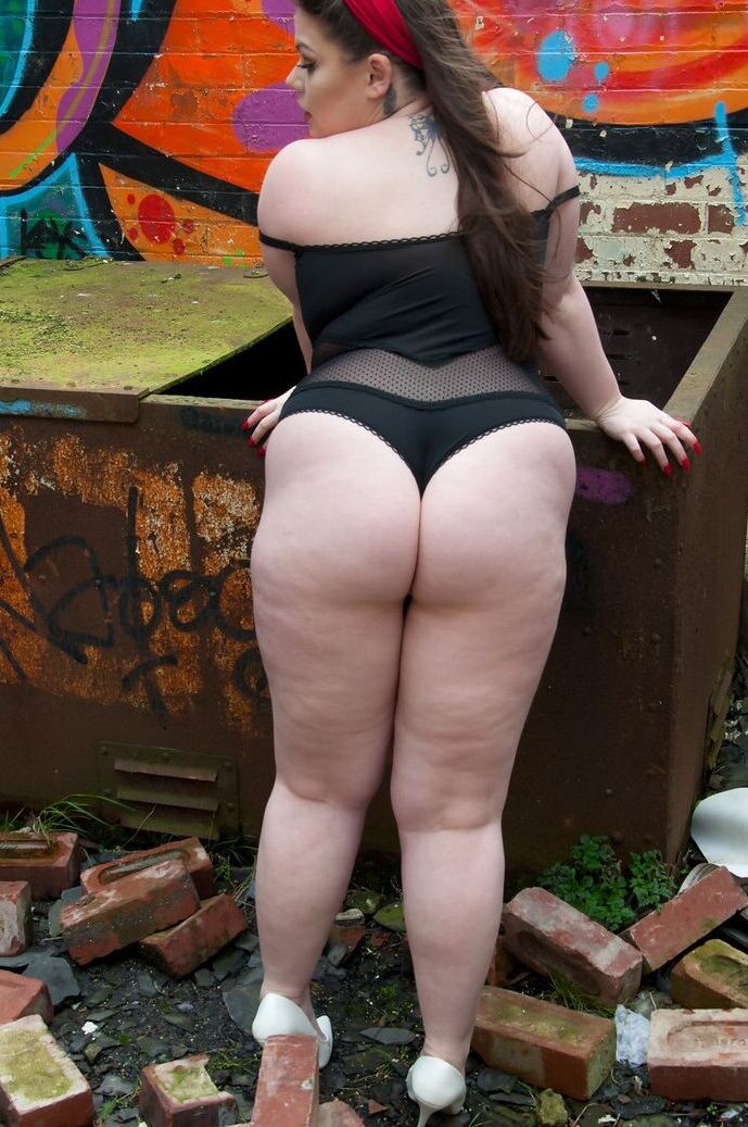 15P Brunette fatty Gina G unleashes her knockers while getting naked near graffiti