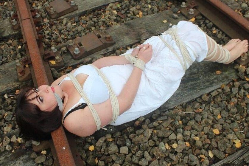 14PブルネットBBWは線路上で縛られ猿ぐつわをされたまま放置される