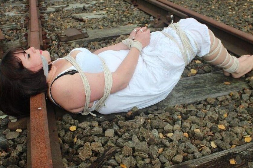 14PブルネットBBWは線路上で縛られ猿ぐつわをされたまま放置される