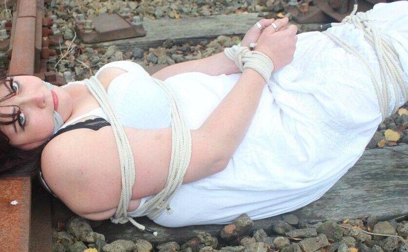 14PブルネットBBWは線路上で縛られ猿ぐつわをされたまま放置される