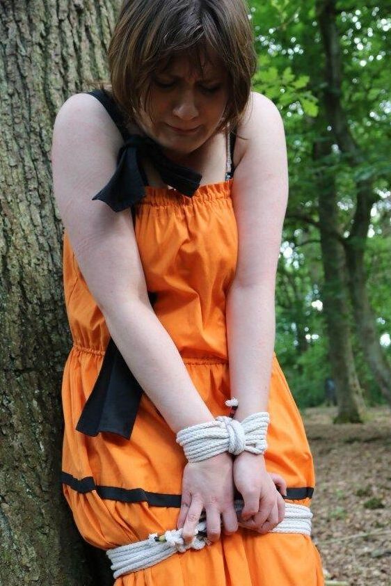 16P 太った女性が猿轡をされ、服を着たまま森の木に縛り付けられる