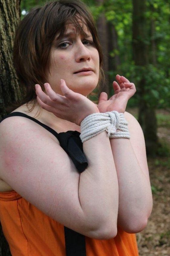 16P 太った女性が猿轡をされ、服を着たまま森の木に縛り付けられる