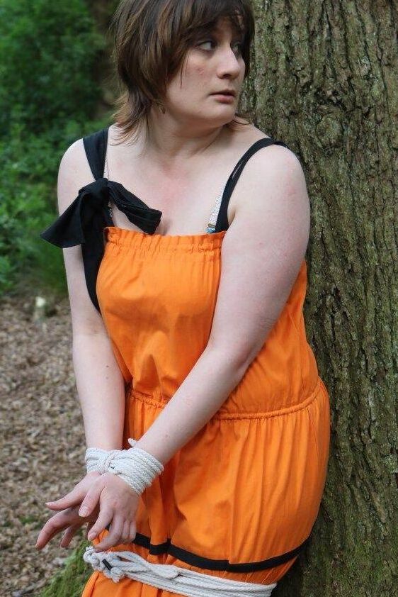 16P 太った女性が猿轡をされ、服を着たまま森の木に縛り付けられる