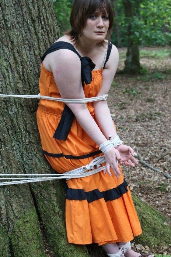 16P 太った女性が猿轡をされ、服を着たまま森の木に縛り付けられる