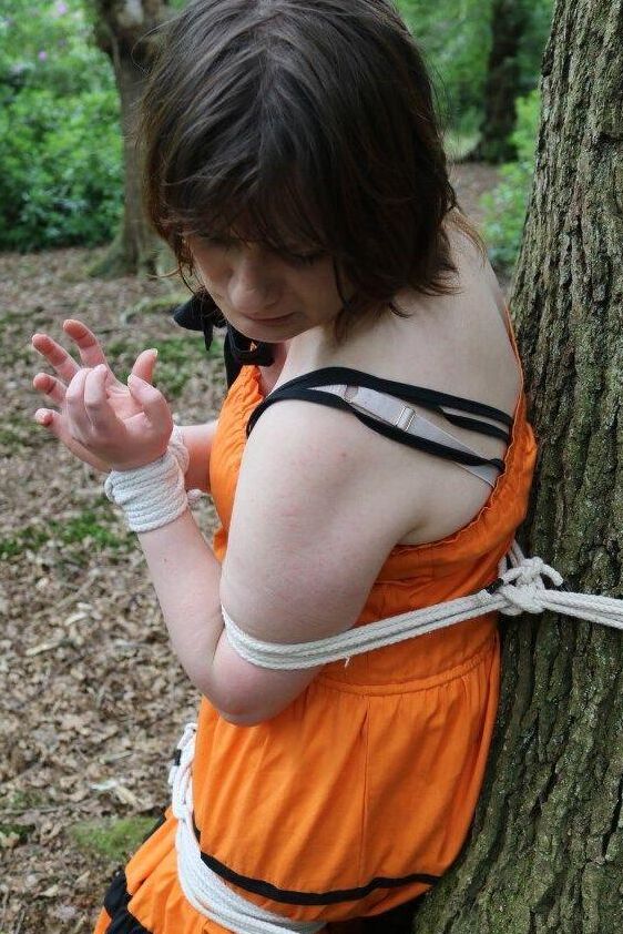 16P 太った女性が猿轡をされ、服を着たまま森の木に縛り付けられる