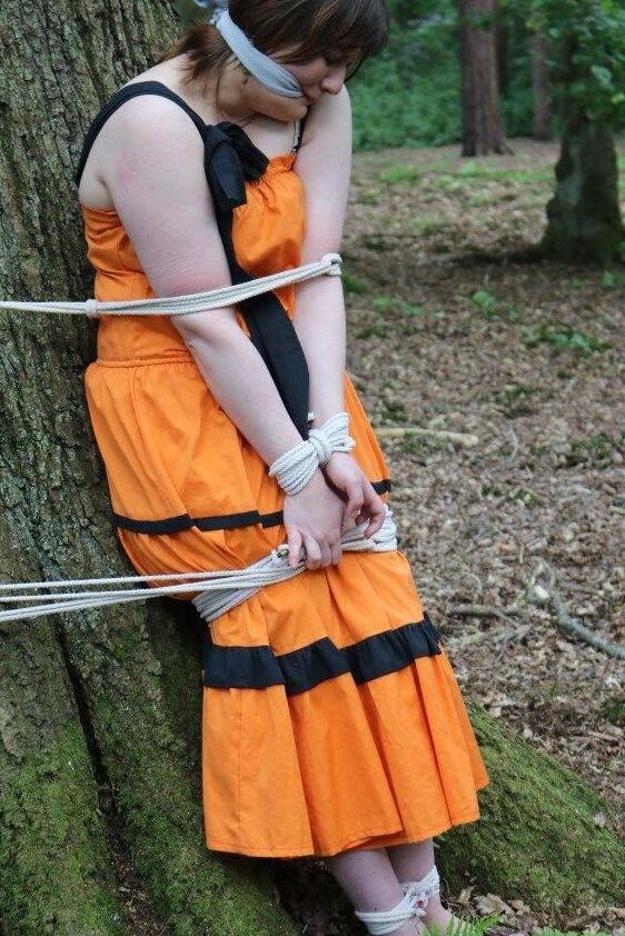 16P 太った女性が猿轡をされ、服を着たまま森の木に縛り付けられる