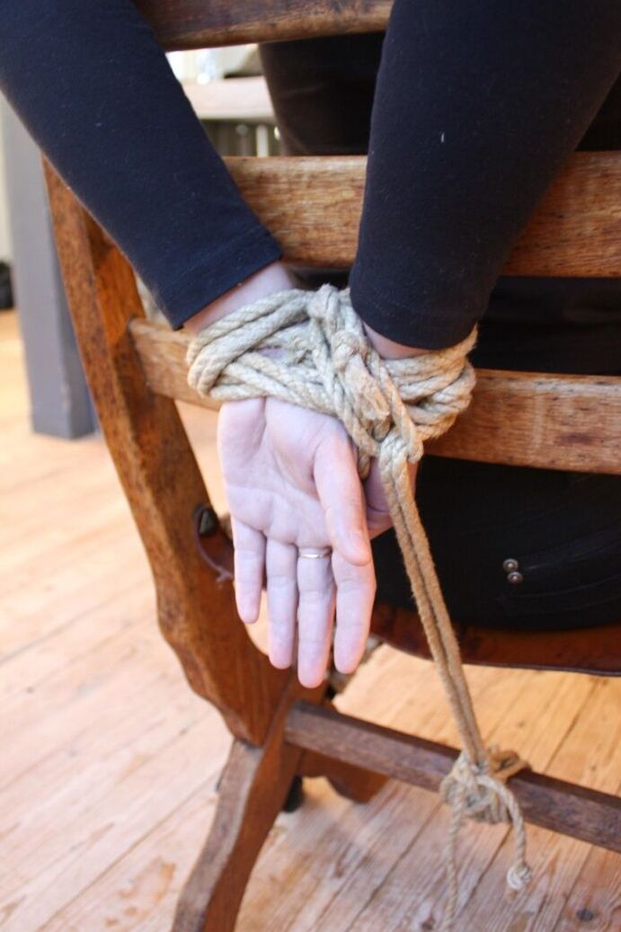 17P Une femme entièrement habillée est attachée à une chaise avec des cordes avant d'être bâillonnée.