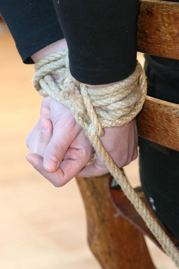 17P Une femme entièrement habillée est attachée à une chaise avec des cordes avant d'être bâillonnée.