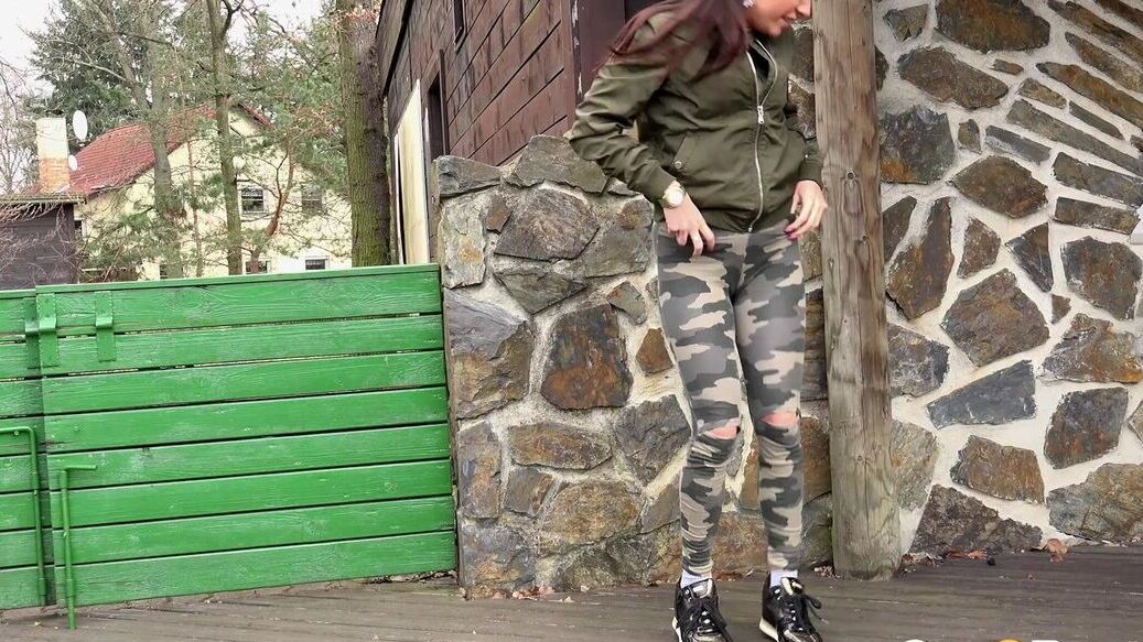 15P Brunette chick Dellai pulls down camo pants for a badly needed pee in public