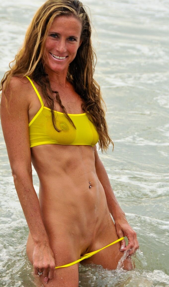 21P La sensuelle MILF Sofie Marie pose dans son bikini jaune transparent dans la mer.