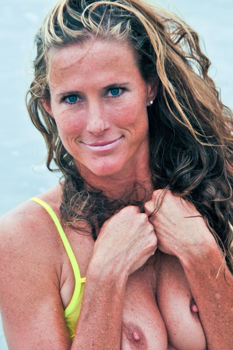 21P La sensuelle MILF Sofie Marie pose dans son bikini jaune transparent dans la mer.