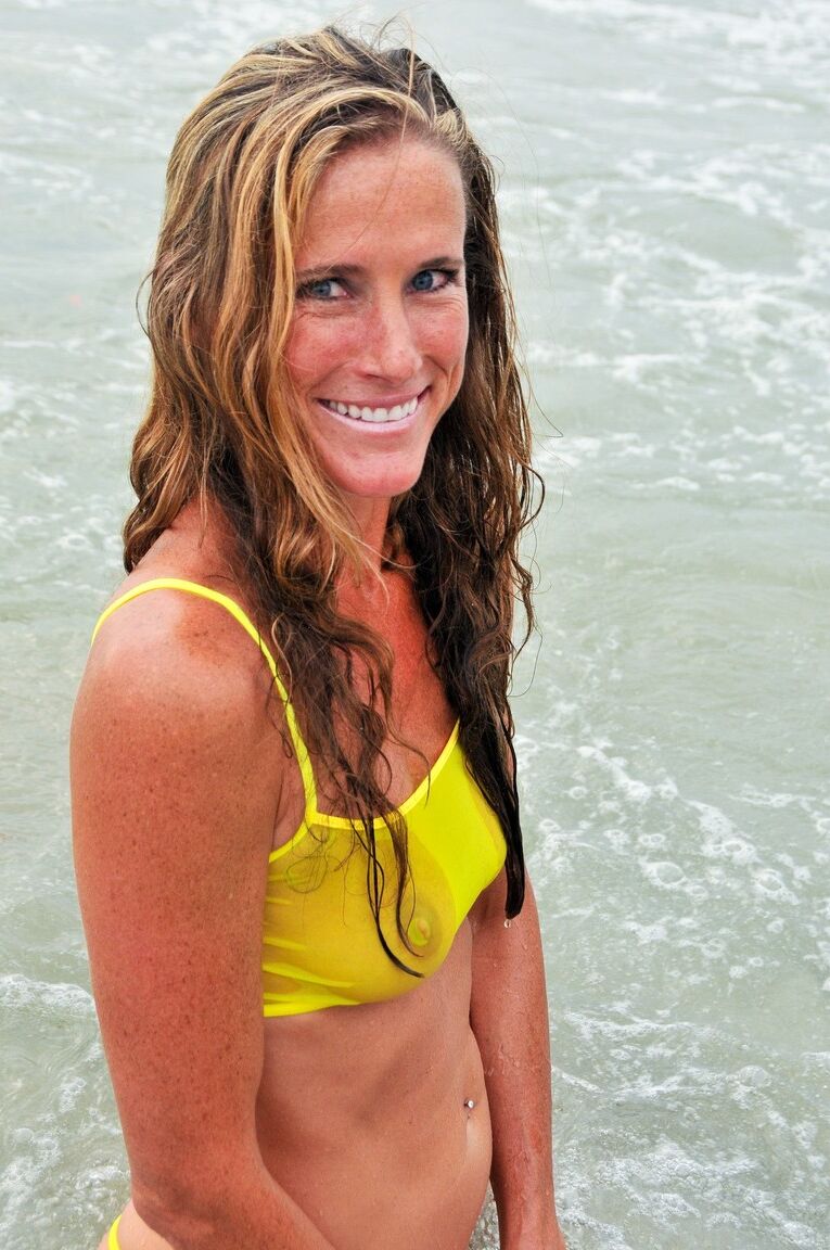 21P La sensuelle MILF Sofie Marie pose dans son bikini jaune transparent dans la mer.