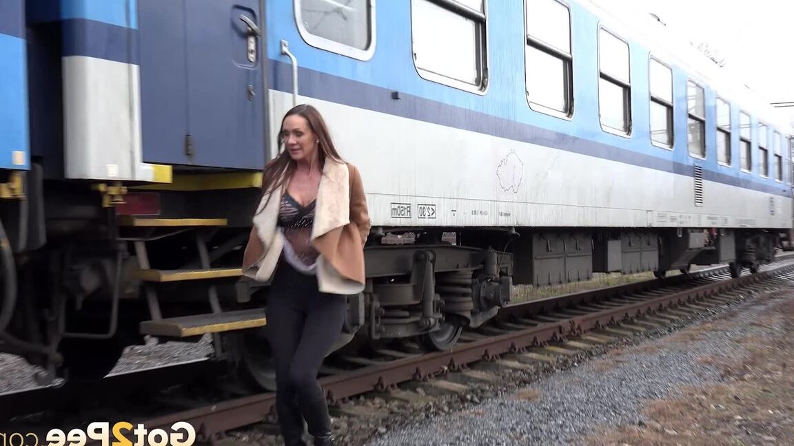 15P Cynthia Vellons pulls down black tights for a quick piss near railway cars