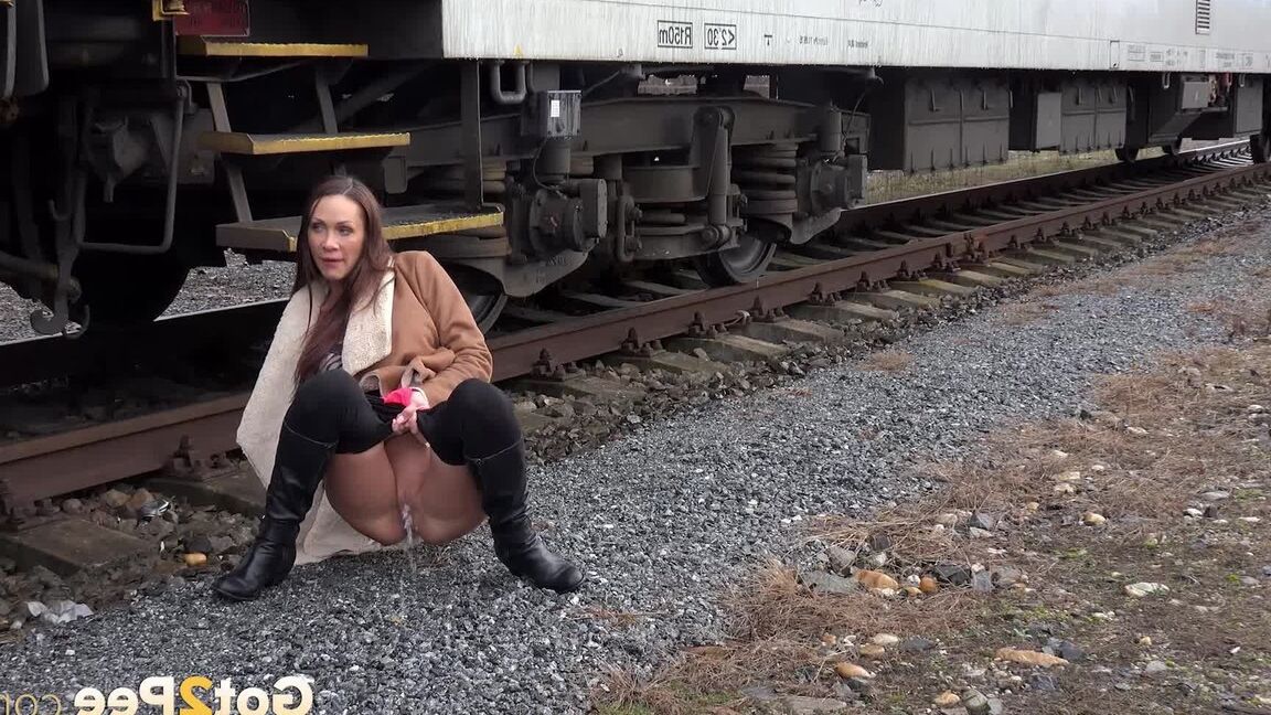 15P Cynthia Vellons pulls down black tights for a quick piss near railway cars