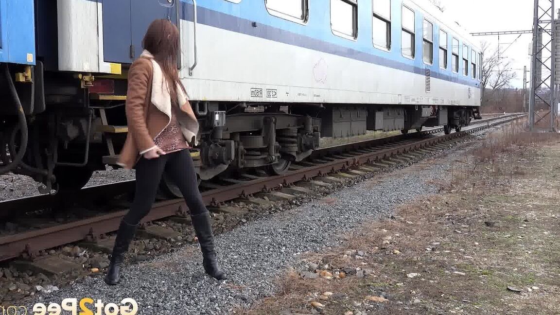 15P Cynthia Vellons pulls down black tights for a quick piss near railway cars