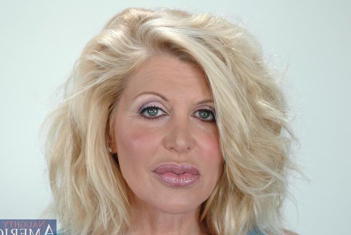 16P Sharon Kane, mature et plantureuse, se déshabille et montre une fente poilue.