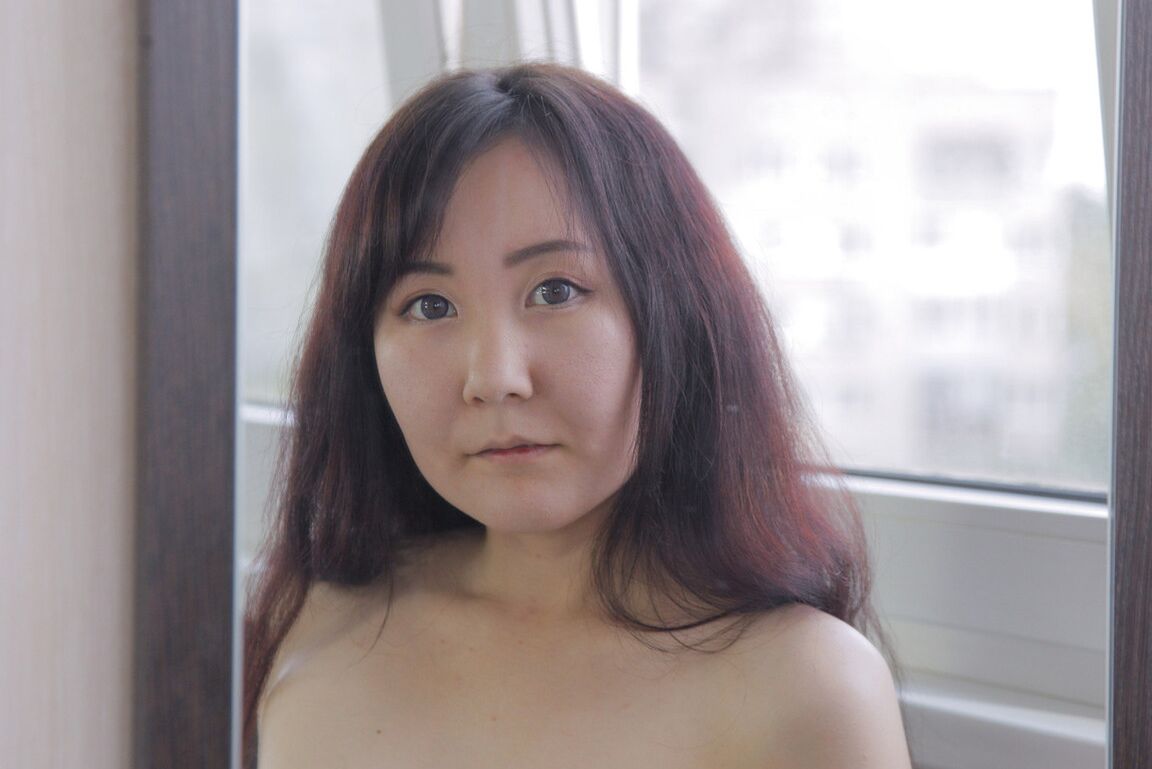20P O adolescente japonês esguio Akuma Loli posa totalmente nu em uma cadeira diante de um espelho