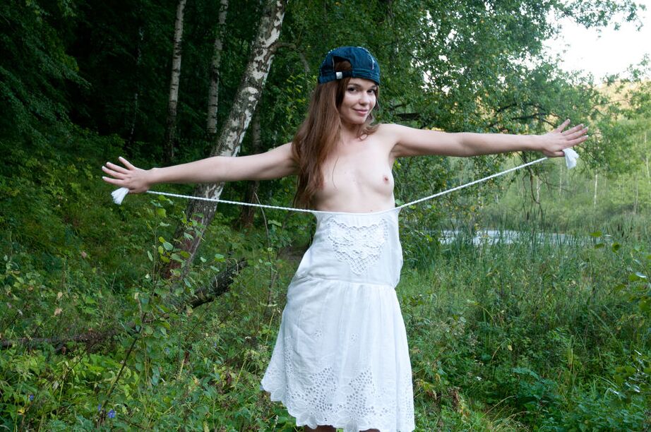 16P La jolie jeune Nedda A enlève une robe blanche pour poser nue sur un arbre tombé