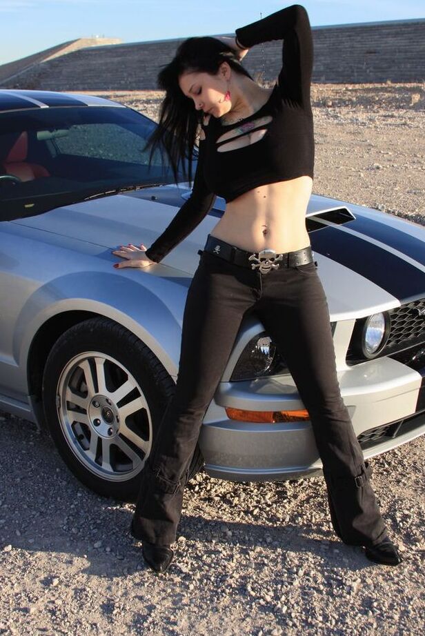 20P Brunette amateur Susy Rocks models by a muscle car during a safe for work gig